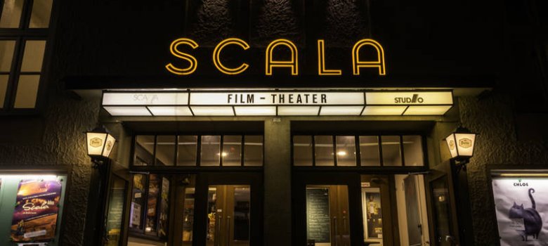 Außenansicht des Kinos Der Eingang des Scala-Filmtheaters im dunkeln mit Beleuchtung