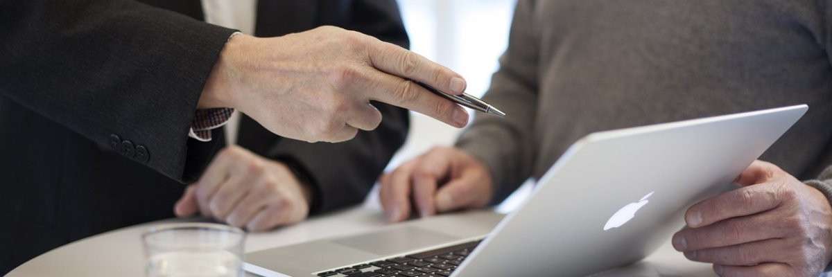 Zwei Personen gemeinsam an einem Bildschirm in einem Gespräch