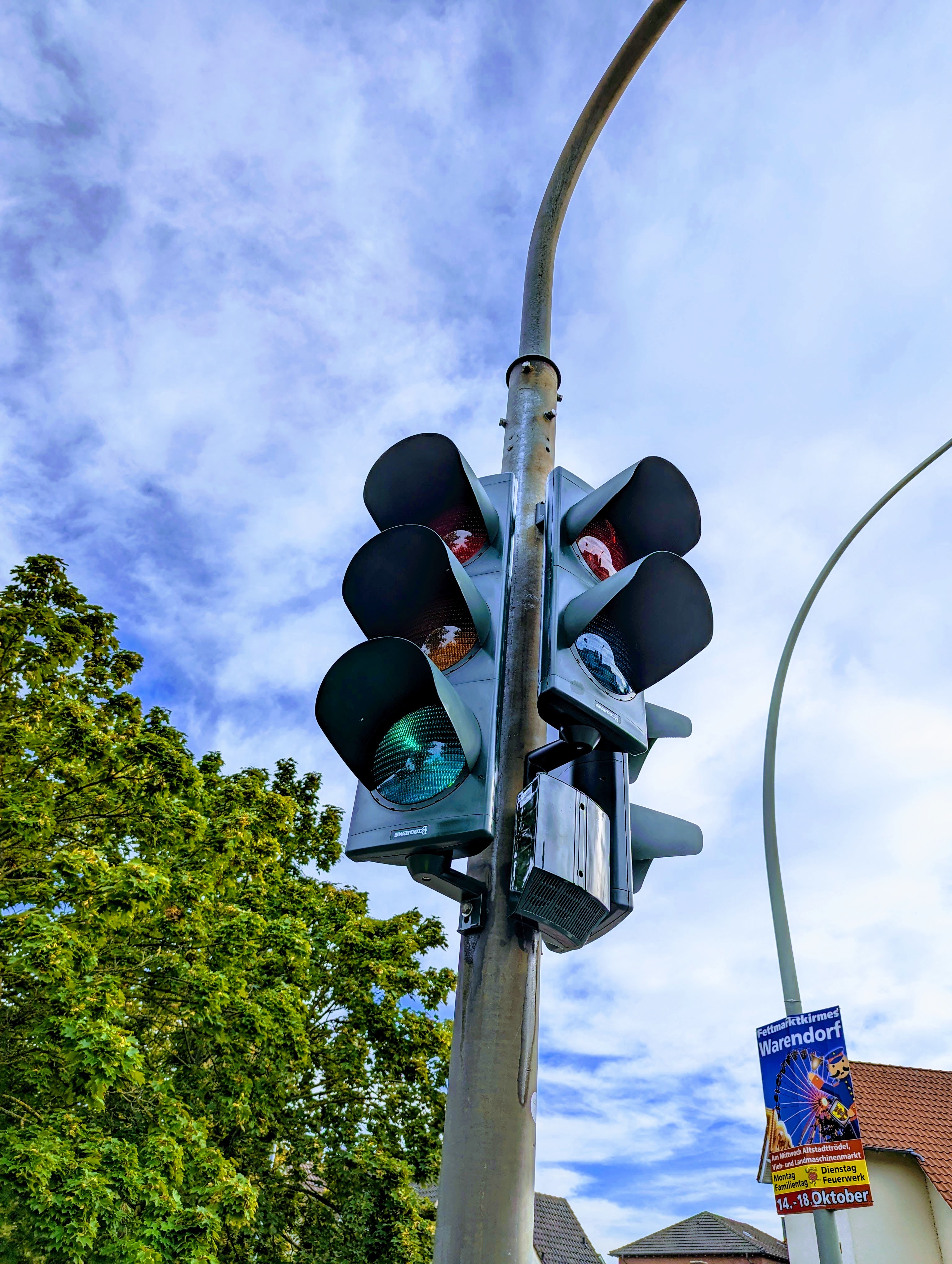 Eine Nahaufnahme eines Signalgebers einer Fußgängerampel die grün für den Autoverkehr zeigt.