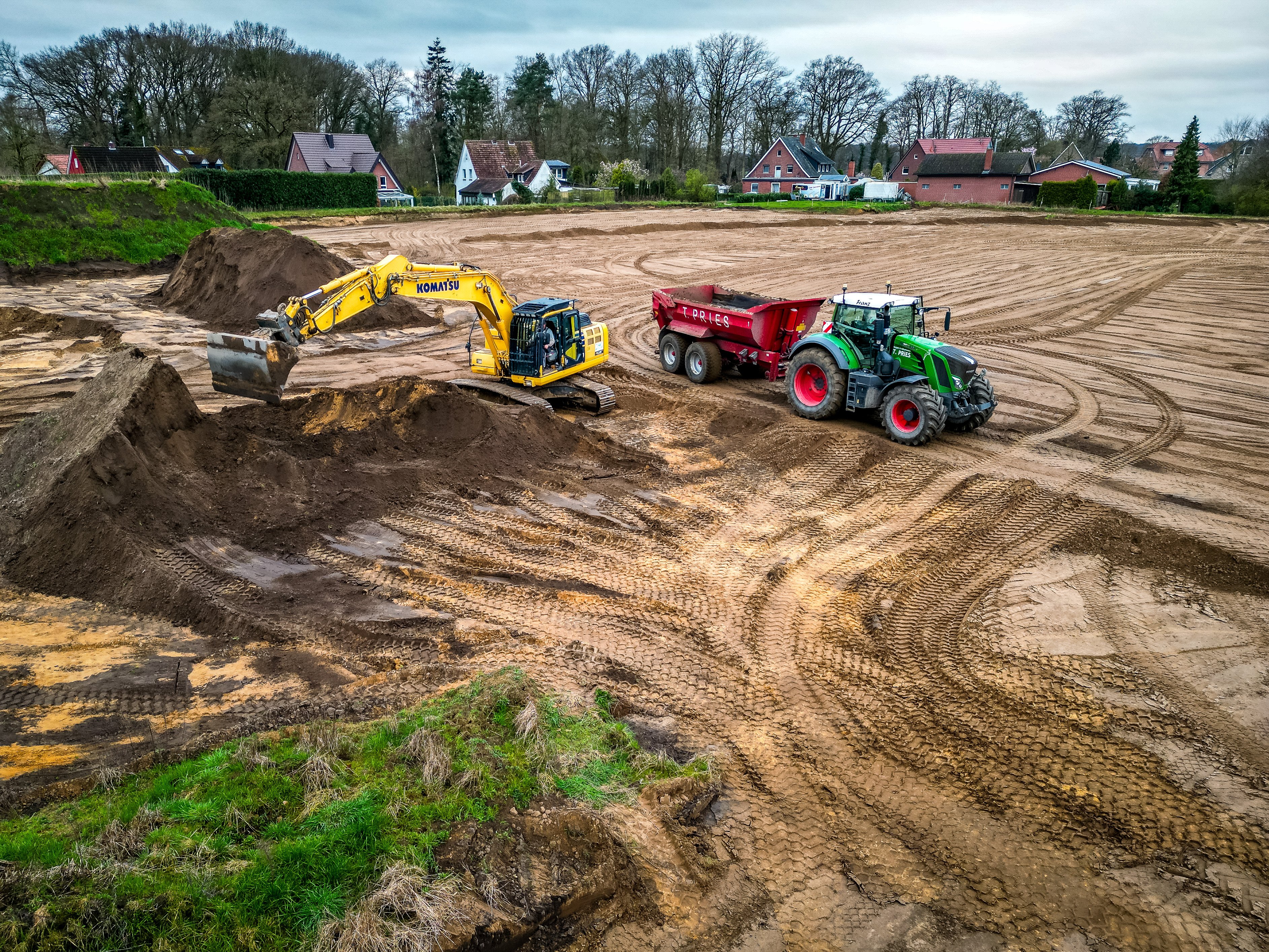 Ein Luftbild von Erdbauarbeiten, es sind mehrere Maschinen zu sehen.