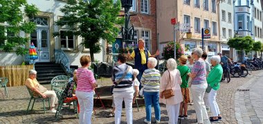Gruppe Touristen auf dem Markplatz bei einer Stadtführung