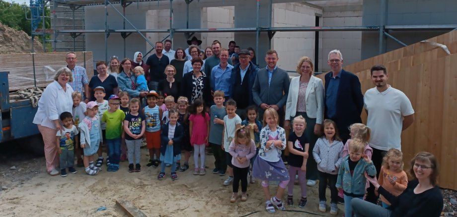 Bürgermeister Peter Horstmann und Investor Heribert Sickmann im Kreis von Mitarbeiterinnen und Mitarbeitern, Investoren und den Dorfzwergen