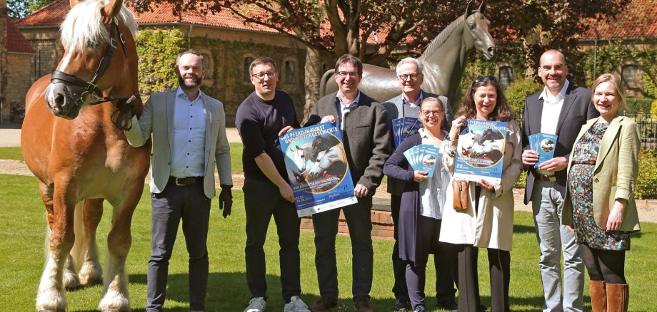 Freuen sich über das Jubiläum des Nordrhein-Westfälischen Landgestüts in Warendorf und das gemeinsame Ausstellungsprojekt (v.l.n.r.): Dr. Felix Austermann (Gestütsleiter und Direktor der Deutschen Reitschule), Martin Koschny (Westpreußisches Landesmuseum), Alfred Smieszchala (Dezentrales Stadtmuseum Warendorf), Wolfgang Türk (Leiter Kulturamt Stadt Warendorf), Maya Kätker (Westfälisches Pferdemuseum), Sybill Ebers (Westfälisches Pferdemuseum), Dr. Sebastian Steinbach (Museum Abtei Liesborn), Katharina Kühl (Museum Abtei Liesborn) … und natürlich Humphrey (Rh.-dt. Kaltblut). 