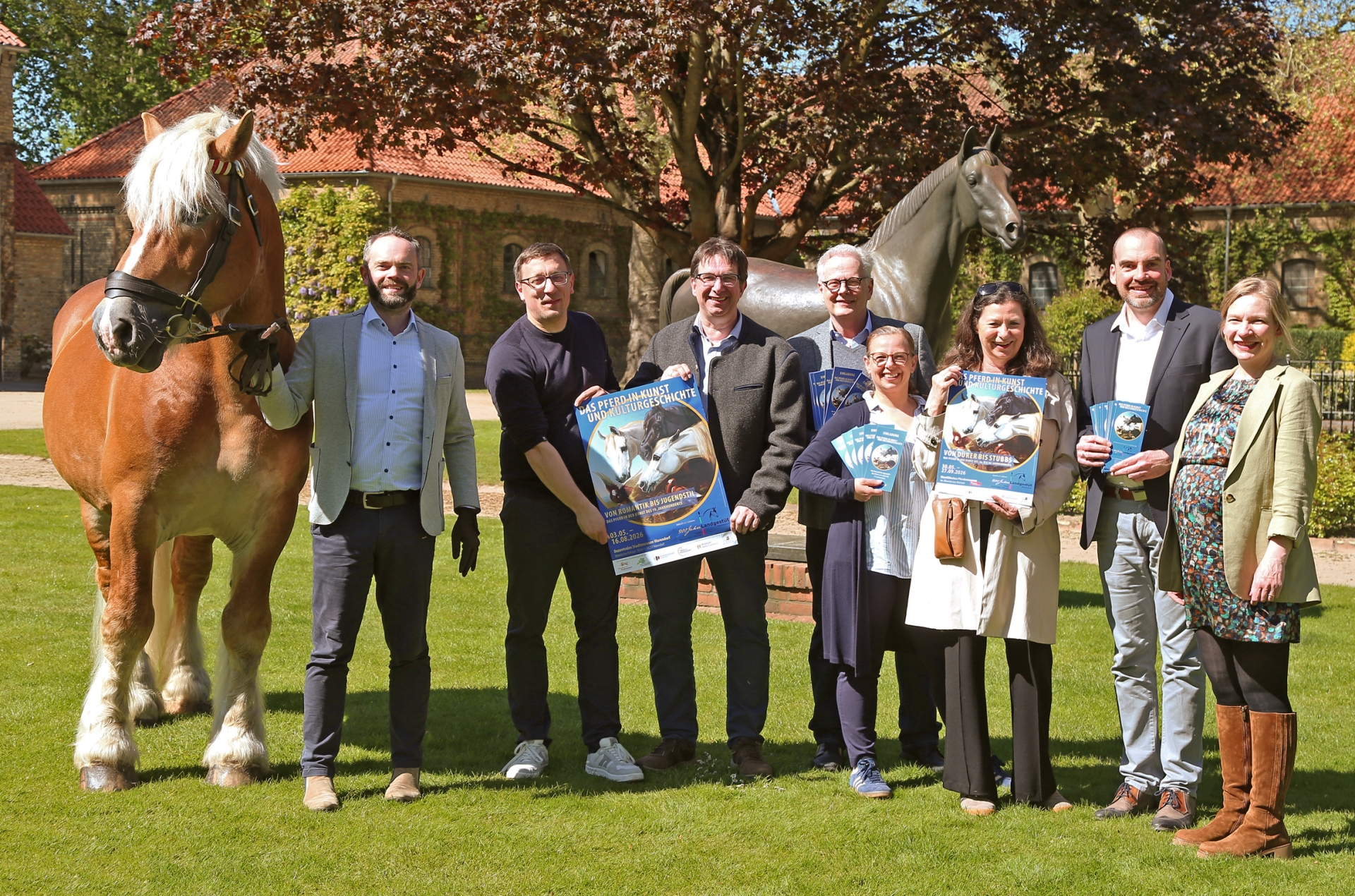 Freuen sich über das Jubiläum des Nordrhein-Westfälischen Landgestüts in Warendorf und das gemeinsame Ausstellungsprojekt (v.l.n.r.): Dr. Felix Austermann (Gestütsleiter und Direktor der Deutschen Reitschule), Martin Koschny (Westpreußisches Landesmuseum), Alfred Smieszchala (Dezentrales Stadtmuseum Warendorf), Wolfgang Türk (Leiter Kulturamt Stadt Warendorf), Maya Kätker (Westfälisches Pferdemuseum), Sybill Ebers (Westfälisches Pferdemuseum), Dr. Sebastian Steinbach (Museum Abtei Liesborn), Katharina Kühl (Museum Abtei Liesborn) … und natürlich Humphrey (Rh.-dt. Kaltblut). 
