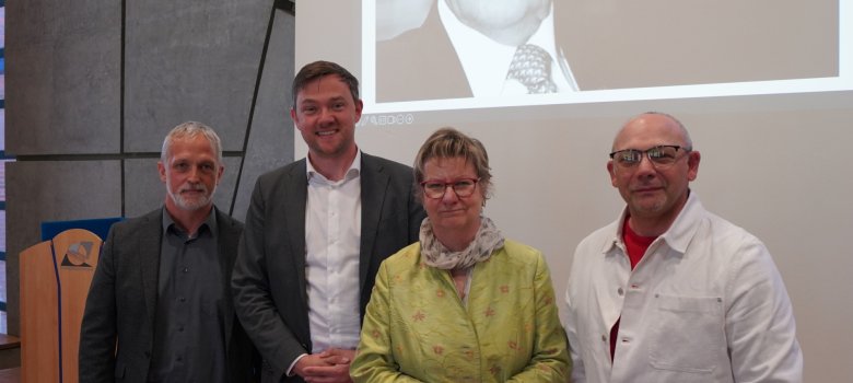 v.l. Udo Lakemper (Schulleiter Paul-Spiegel-Berufskolleg), Bürgermeister Peter Horstmann, Sylvia Löhrmann (Beauftragten des Landes Nordrhein-Westfalen für die Bekämpfung des Antisemitismus, für jüdisches Leben und Erinnerungskultur), Ilja Golub (Jüdische Gemeinde Münster) vor dem Bild von Paul Spiegel